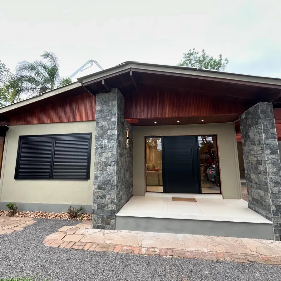 Casa com esquadrias de alumínio pretas: porta lambri e janelas