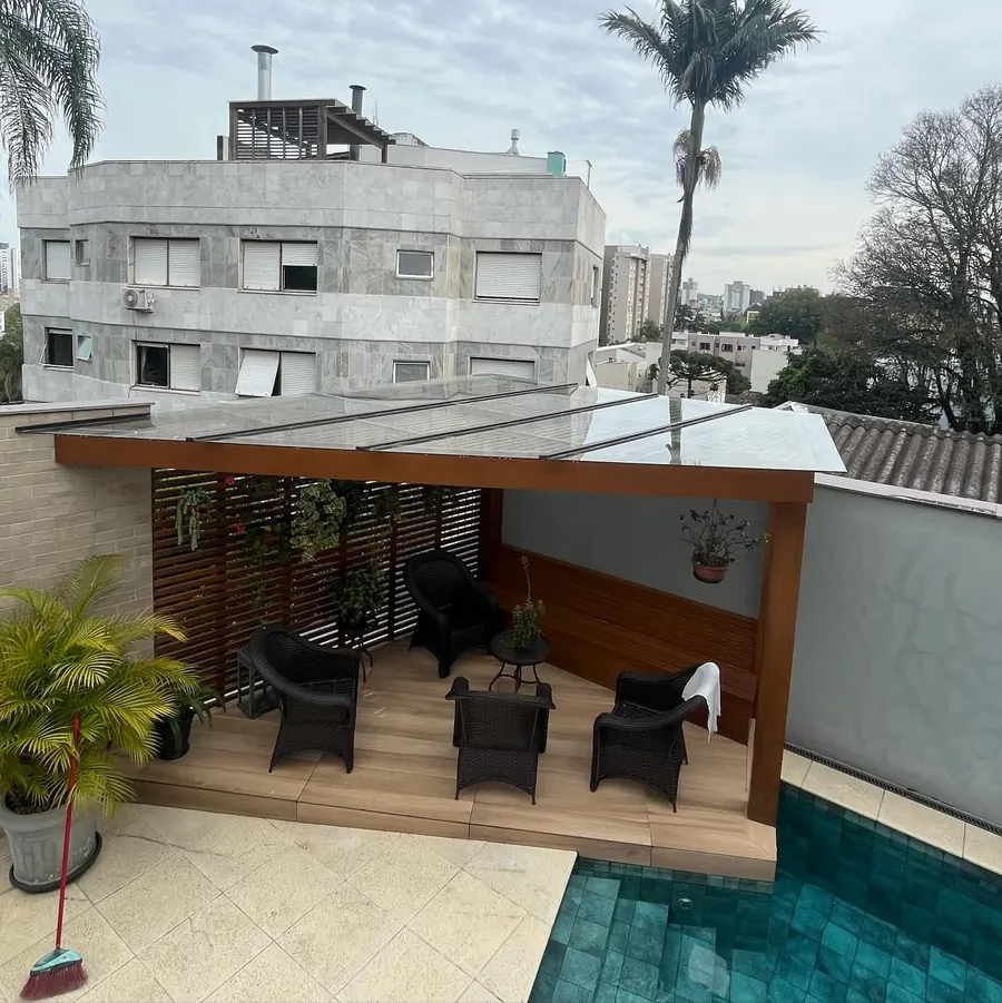 Pergolado de vidro com alumínio bronze sobre área com piscina