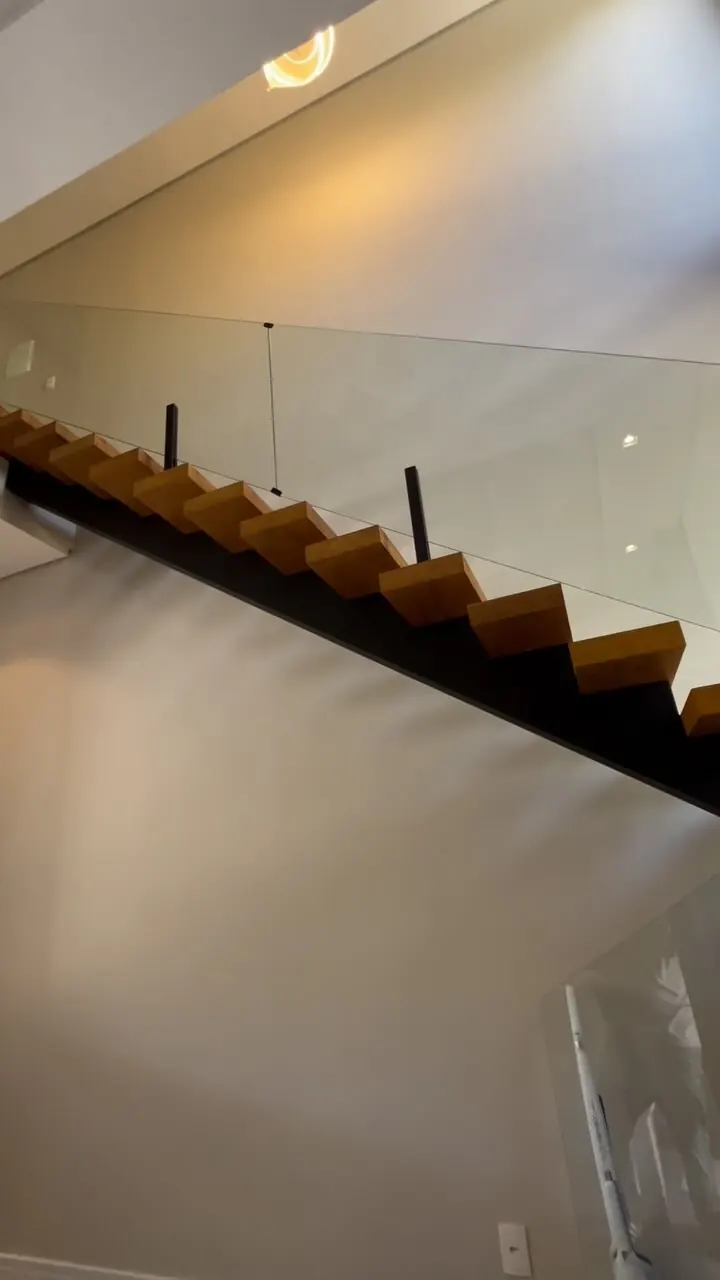 Escada com guarda-corpo de vidro e torres de pinça de inox preto