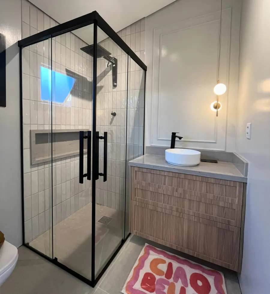 Box de canto com vidro incolor e kit preto em banheiro