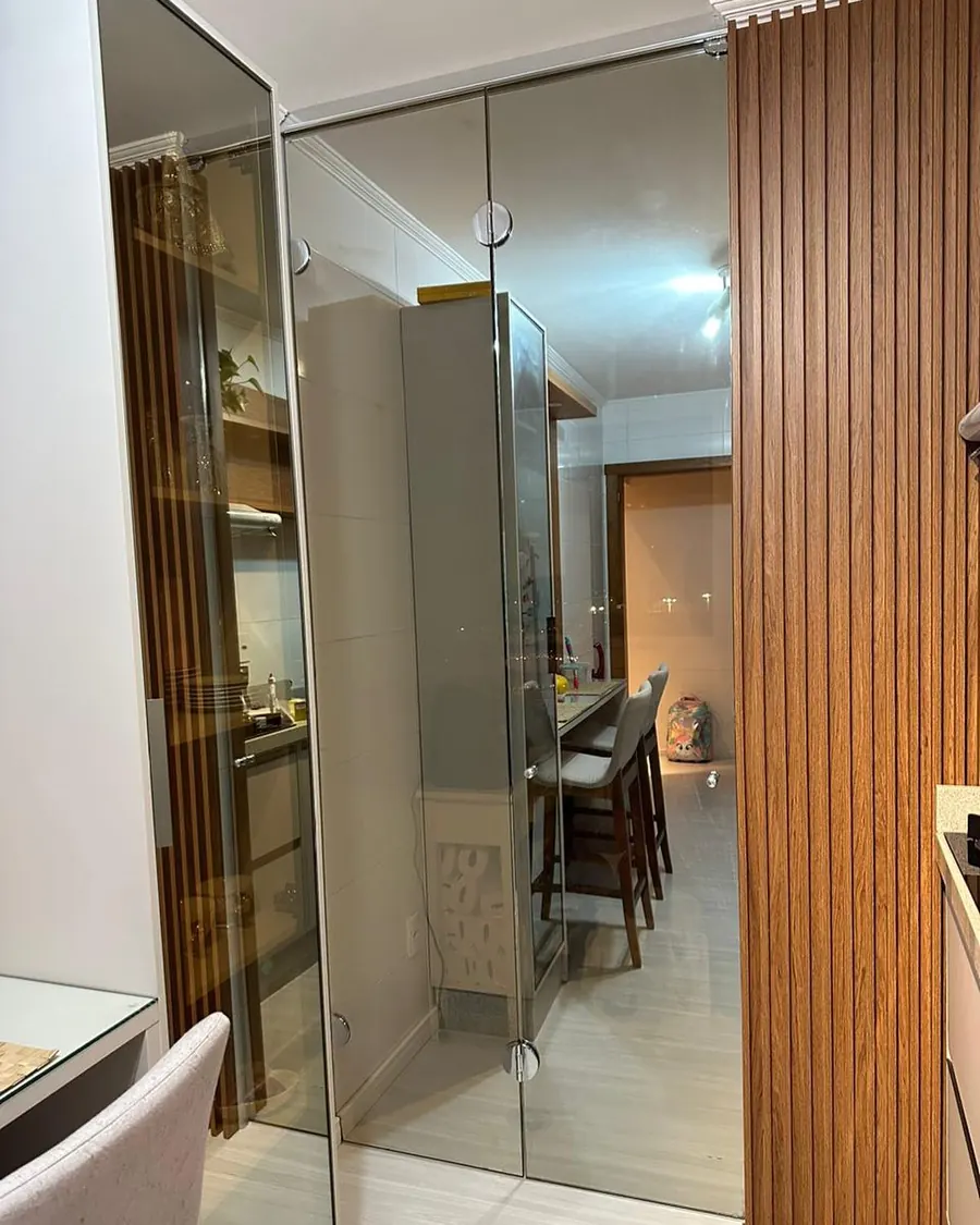 Divisória sanfonada em vidro reflecta champanhe em apartamento