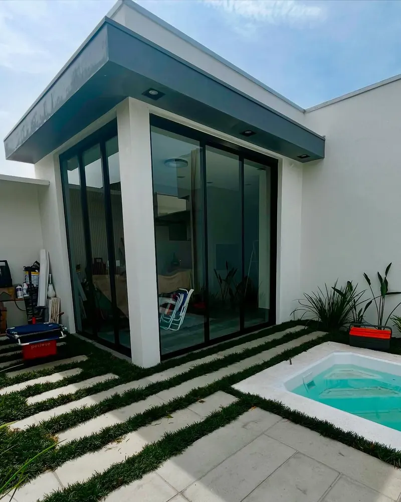 Porta de correr três folhas em alumínio preto linha Suprema em casa com piscina